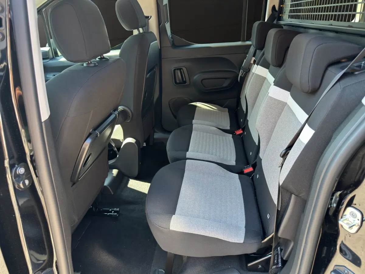 Vue intérieure côté droit sur la banquette arrière grise et noire du Citroën Berlingo noir 2026 avec grille de séparation.