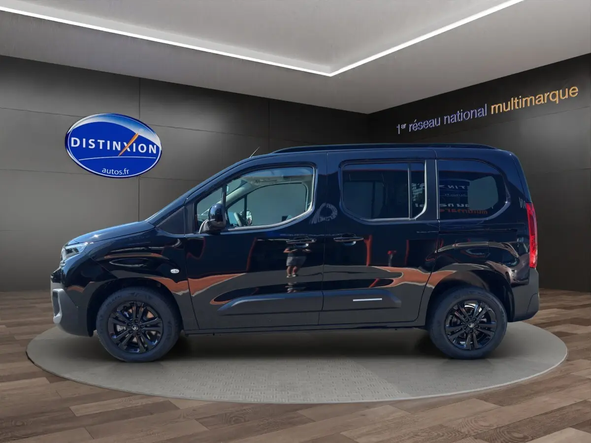 Vue de profil côté gauche d'un Citroën Berlingo noir 2026 avec jantes noires et vitres teintées en showroom.