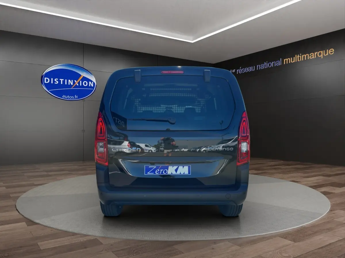 Vue arrière du Citroën Berlingo noir 2026 avec logo et plaque Zero KM dans un showroom intérieur.