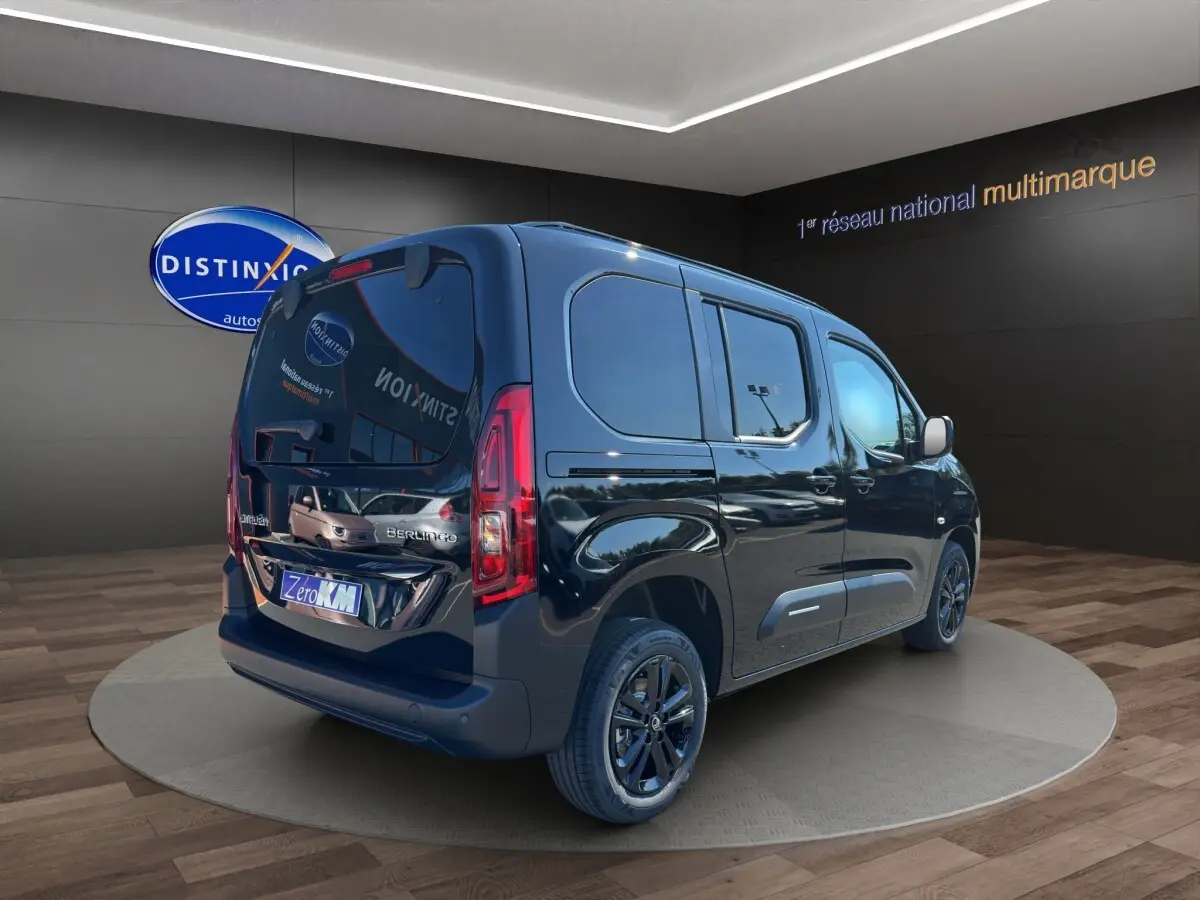 Vue 3/4 arrière droite du Citroën Berlingo noir 2026 avec vitres teintées et jantes noires en showroom.
