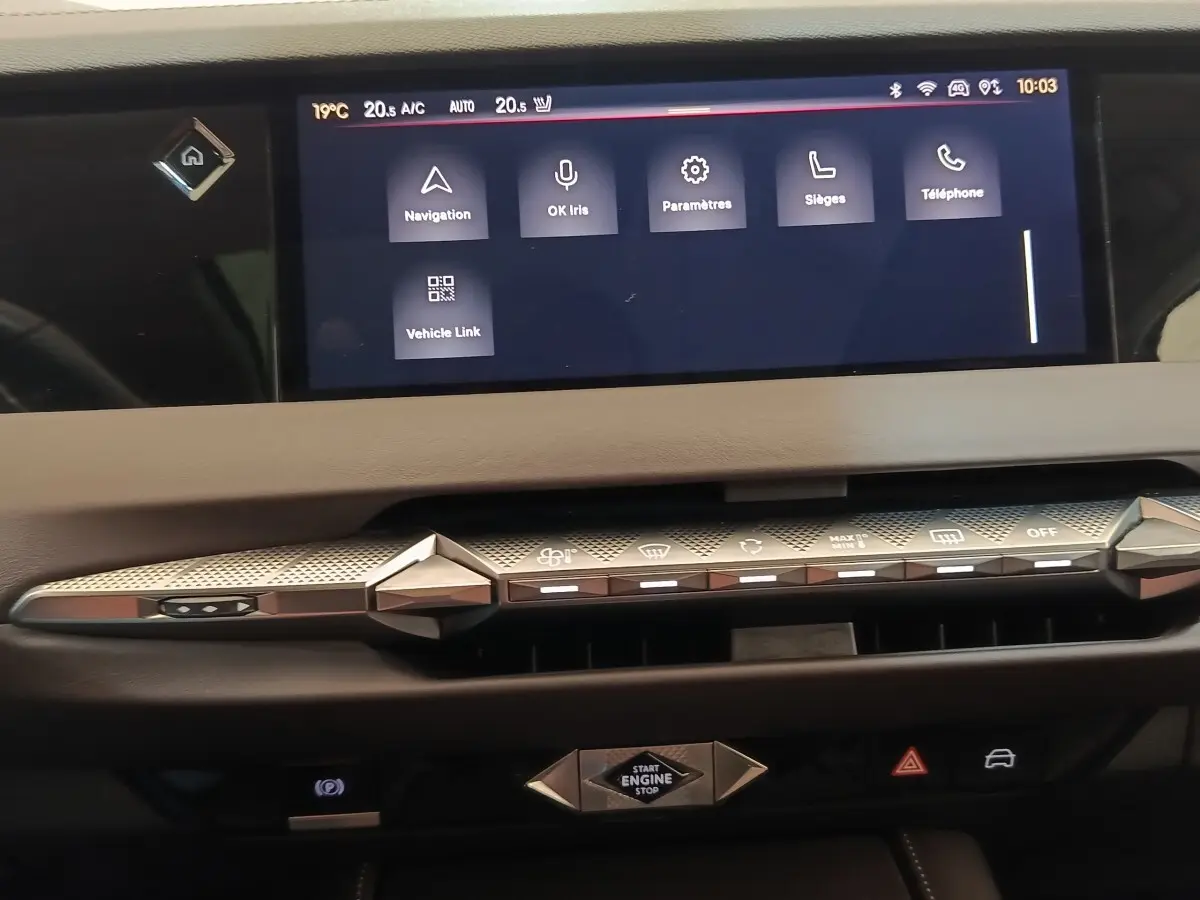 Vue rapprochée du tableau de bord gris clair de la DS4 E-TENSE 225 avec écran tactile et commandes design géométriques.