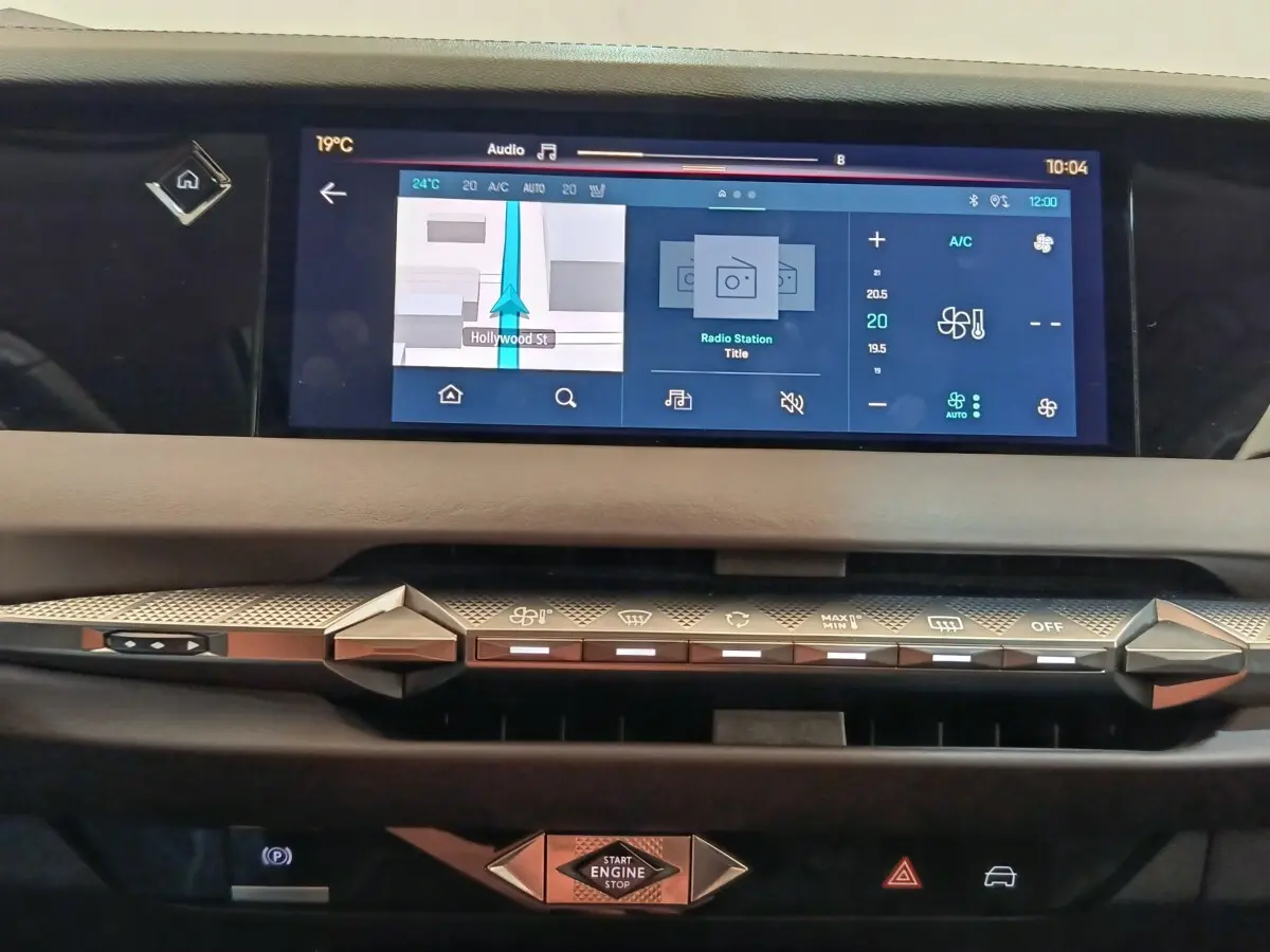 Vue rapprochée du tableau de bord tactile et des commandes de climatisation du DS4 E-TENSE gris clair de 2021.