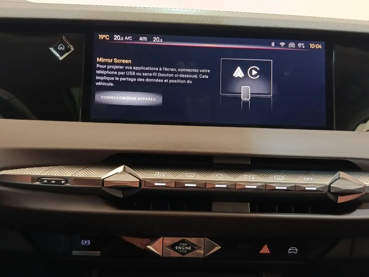 Vue rapprochée du tableau de bord de la DS4 E-TENSE 225 gris clair, mettant en valeur l'écran tactile et les commandes design.