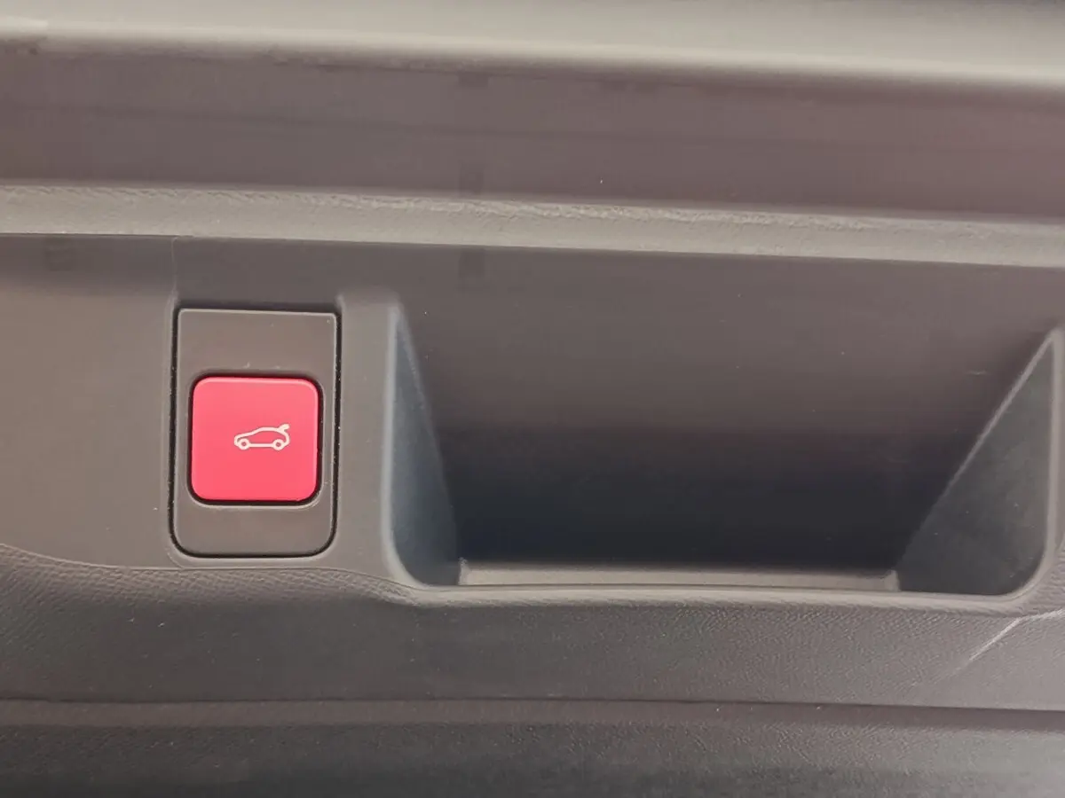 Bouton rouge d'ouverture électrique du coffre sur panneau intérieur d'une DS4 E-TENSE gris clair de 2021.