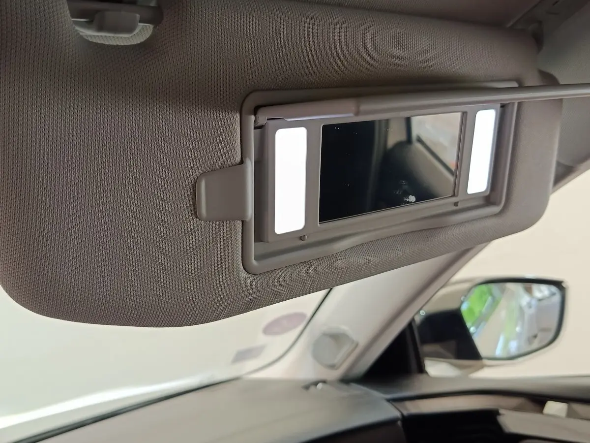 Détail du pare-soleil avec miroir éclairé dans l’habitacle clair d’une DS4 E-TENSE 225 gris clair, vue côté droit.