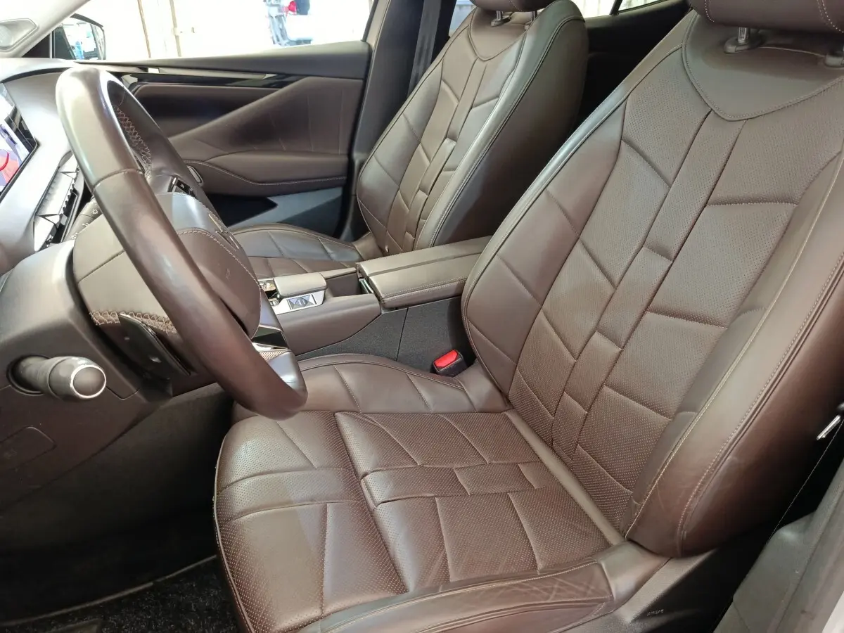 Intérieur avant droit du DS4 E-TENSE 225 LA PREMIERE 2021 avec sièges cuir marron et volant cuir réglable.