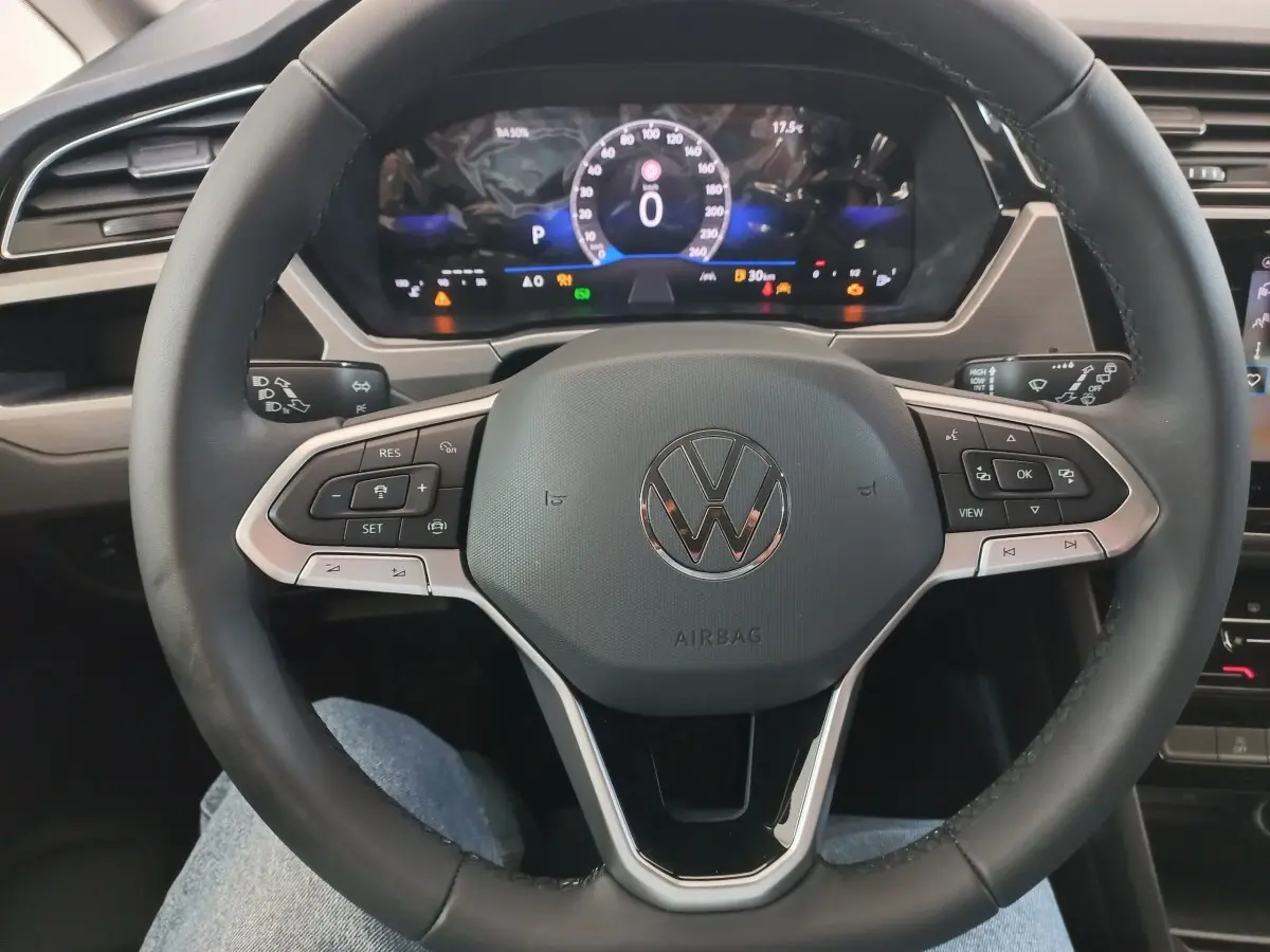 Vue rapprochée du volant noir multifonctions et du combiné d'instruments digital du Volkswagen Touran 2024.