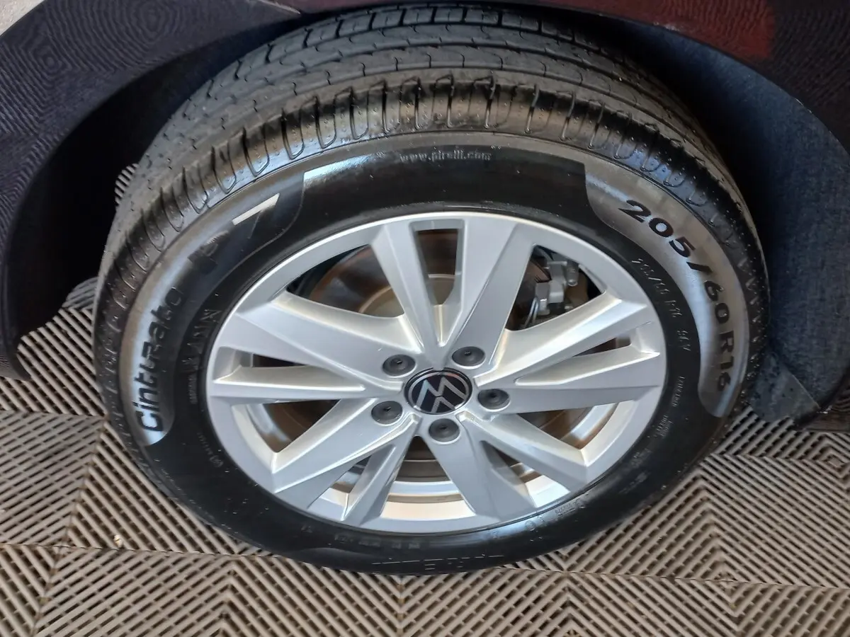 Gros plan sur la roue avant gauche du Volkswagen Touran noir, jante alliage argentée et pneu Pirelli Cinturato P7.