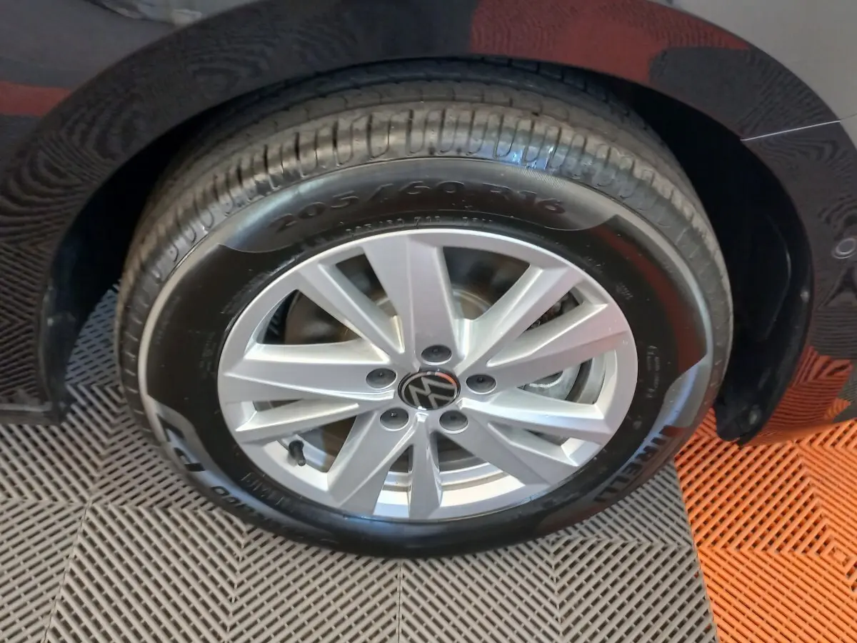 Gros plan sur la roue avant droite noire d’un Volkswagen Touran 2024 avec jante argentée et pneu Pirelli.