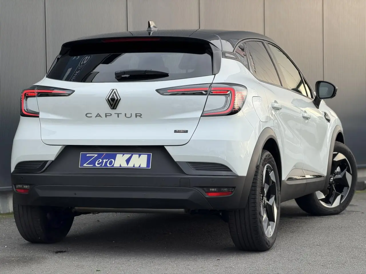 Vue 3/4 arrière droite du Renault Captur blanc nacré avec toit noir et jantes aluminium 18 pouces Black Hole.
