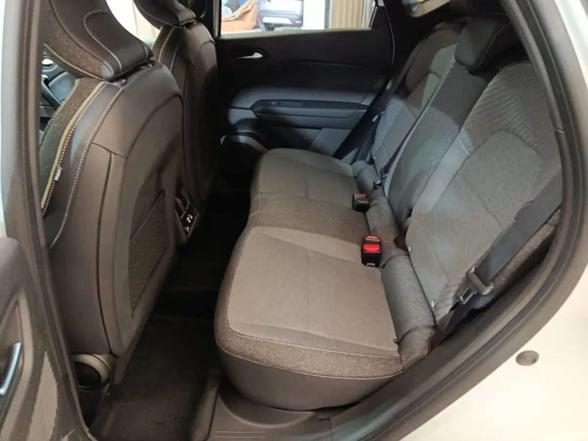 Vue intérieure côté droit des sièges arrière gris du Renault Captur blanc 2025, avec ceinture de sécurité visible.