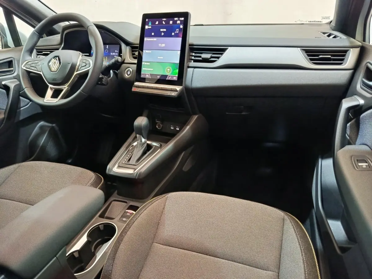 Intérieur du Renault Captur Techno E-Tech 2025, vue avant centrée sur tableau de bord et écran tactile vertical.