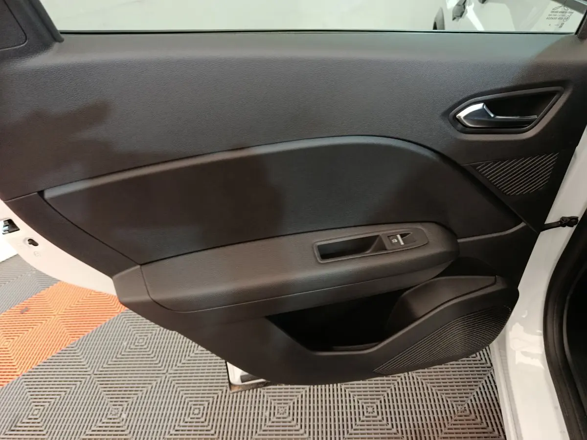 Vue intérieure de la porte avant droite noire du Renault Captur Techno E-Tech 2025 avec poignée et commande de vitre électrique.