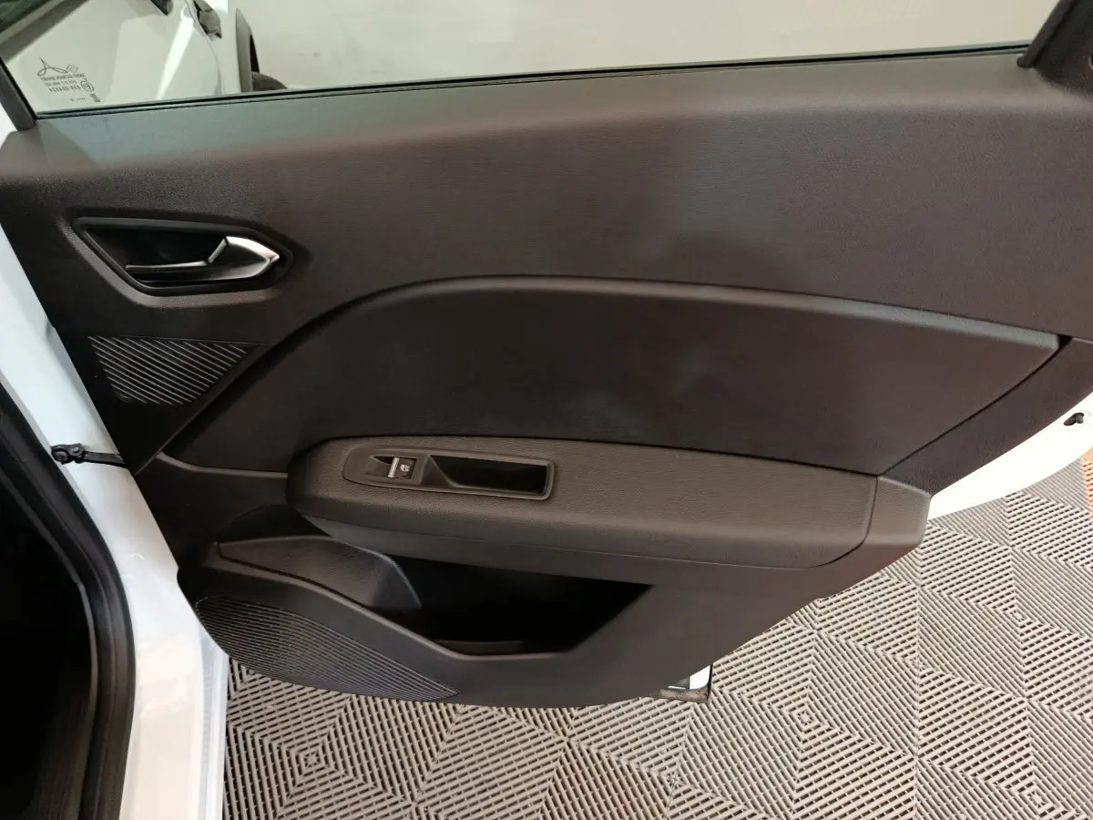 Vue intérieure de la porte avant gauche noire du Renault Captur blanc 2025, avec commande de vitre électrique.