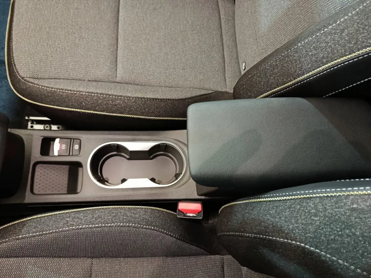 Vue rapprochée de la console centrale et des sièges gris avec surpiqûres jaunes du Renault Captur Techno E-Tech 2025.