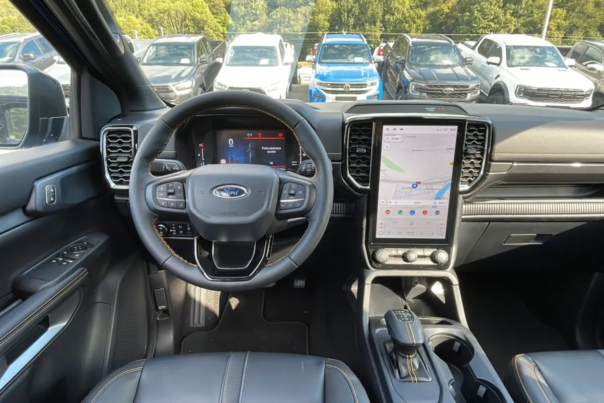 Vue intérieure avant du Ford Ranger 2025 bleu lightning, mettant en valeur le volant cuir et l'écran tactile vertical.
