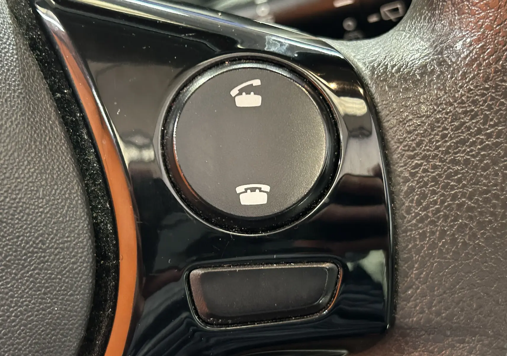 Gros plan sur les boutons de commande d’appel téléphonique sur le volant d’un Peugeot 108 blanc de 2014.