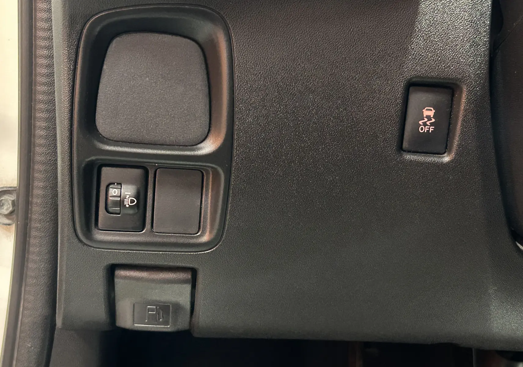 Détail du tableau de bord côté gauche de la Peugeot 108 blanc, avec commandes d'éclairage et bouton de contrôle de stabilité.