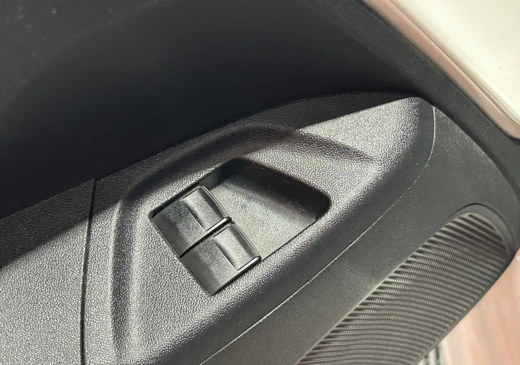 Gros plan sur les commandes de lève-vitres côté conducteur d'une Peugeot 108 blanche, version 2014.