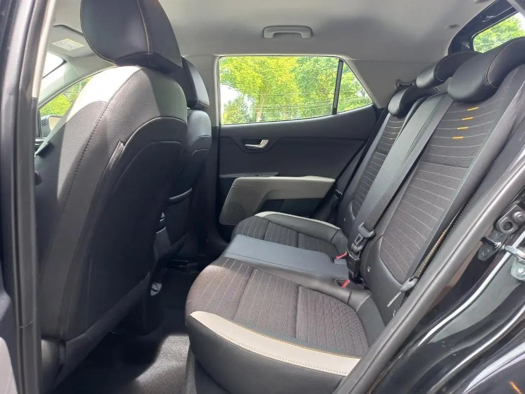 Vue intérieure côté droit des sièges arrière noirs avec surpiqûres jaunes du Kia Stonic 2025 noir, version Collection essence automatique.