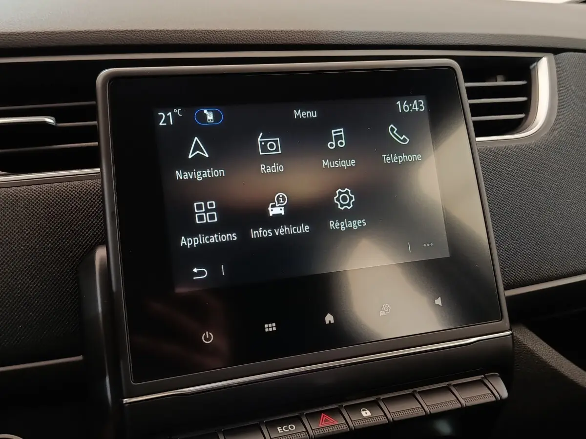 Écran tactile central affichant le menu multimédia dans l’habitacle sombre d’une Renault ZOE blanche 2021.