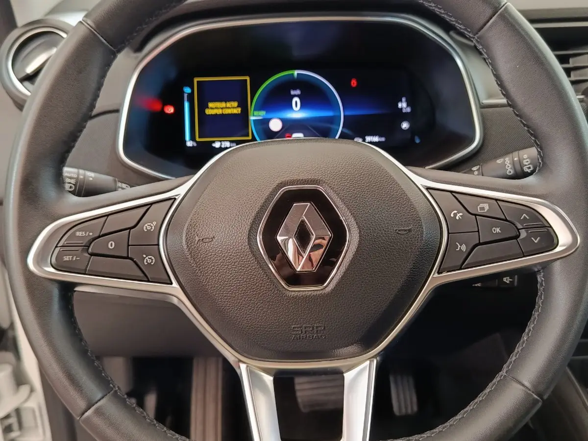 Vue rapprochée du volant cuir noir multifonctions de la Renault ZOE Business Rev R110 blanc, avec tableau de bord digital.