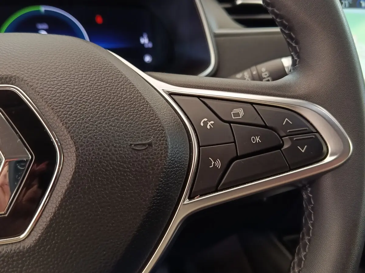 Gros plan sur le volant en cuir synthétique noir de la Renault ZOE 2021, avec commandes multifonctions à droite.