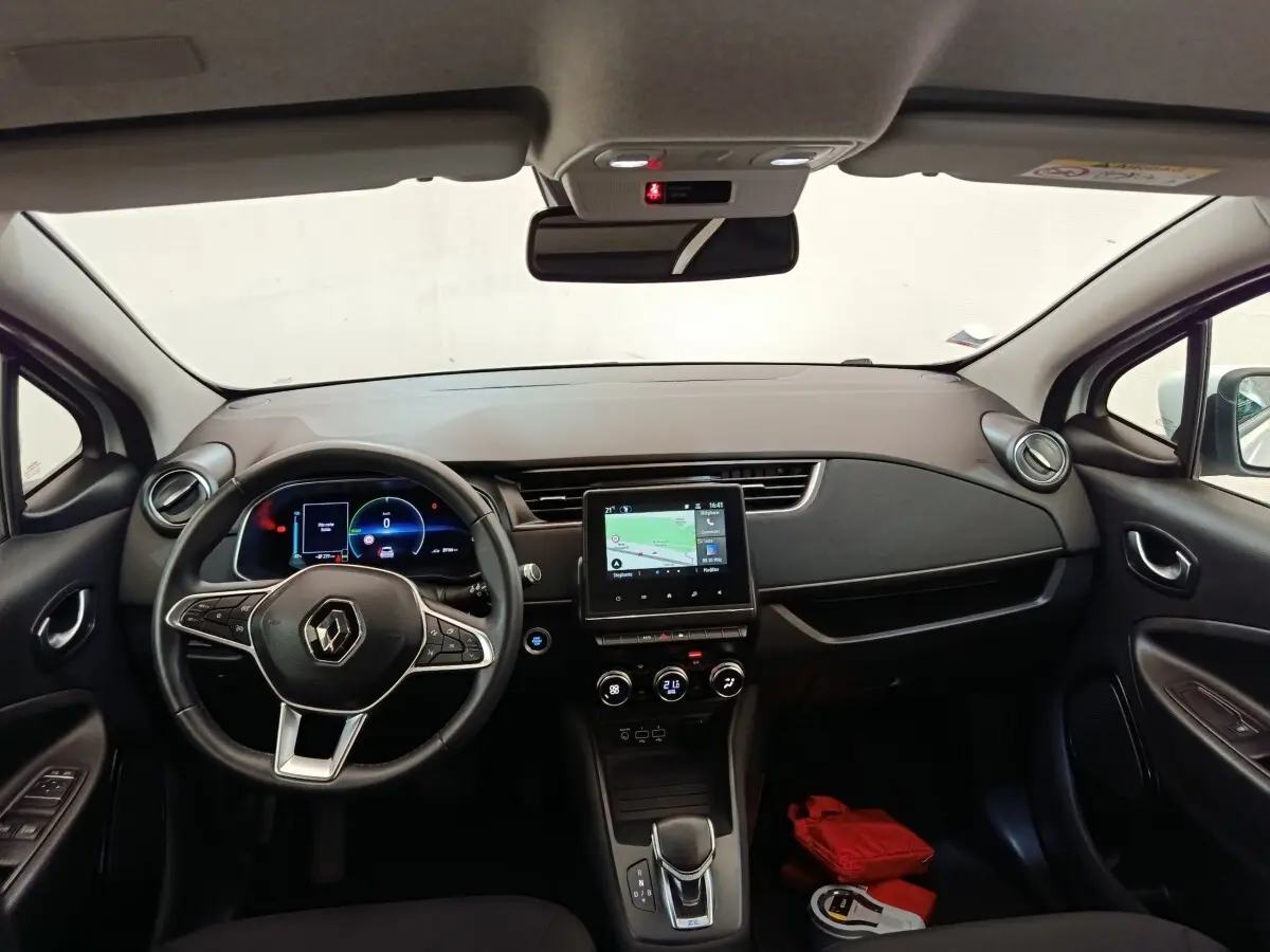 Vue intérieure avant de la Renault ZOE Business 2021, tableau de bord noir avec écran tactile central et volant multifonctions cuir synthétique.