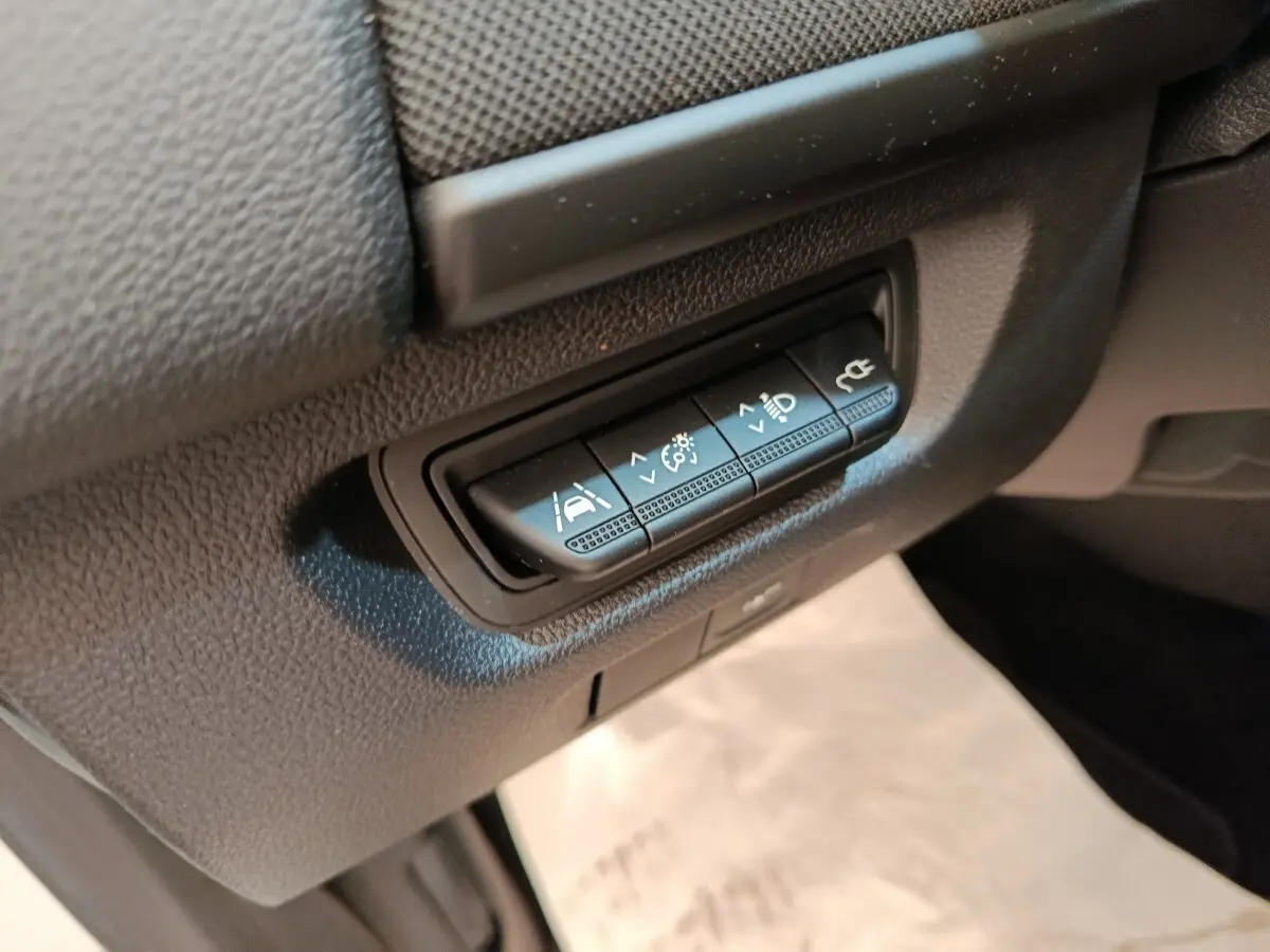Gros plan sur les boutons de réglages d'assistance et éclairage dans l'habitacle de la Renault ZOE blanche 2021.