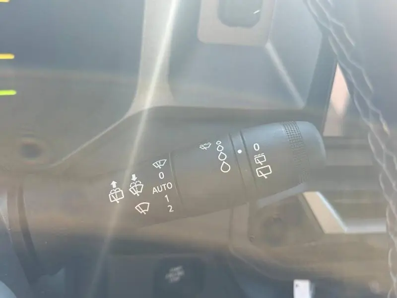 Gros plan sur la commande de essuie-glaces du Dacia Bigster gris schiste, avec symboles blancs visibles.