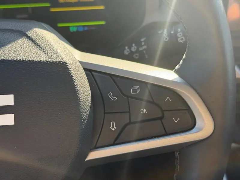 Gros plan sur les commandes multifonctions à droite du volant du Dacia Bigster 2025, éclairage naturel soulignant les boutons noirs.