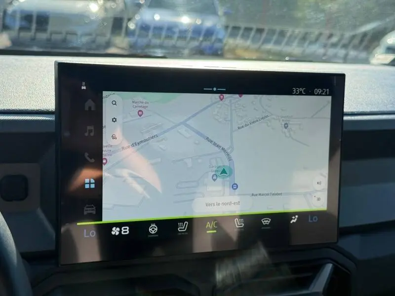 Écran tactile central du tableau de bord du Dacia Bigster gris Schiste, affichant la navigation GPS en plein jour.