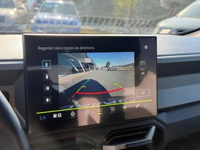 Écran tactile intérieur du Dacia Bigster 2025 montrant la caméra de recul avec vue arrière de la route.