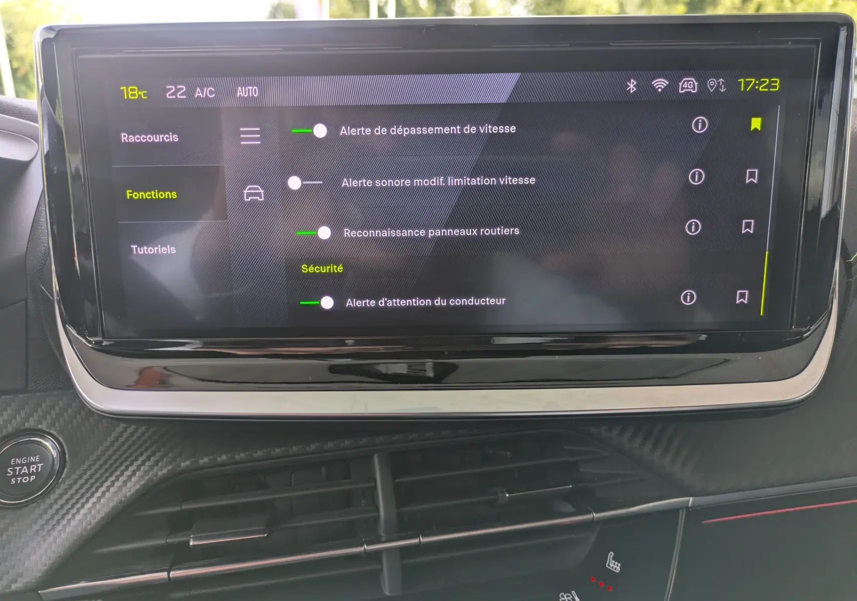 Écran tactile central de la Peugeot 208 Hybrid 145 GT affichant les réglages d'alerte et sécurité, intérieur noir.