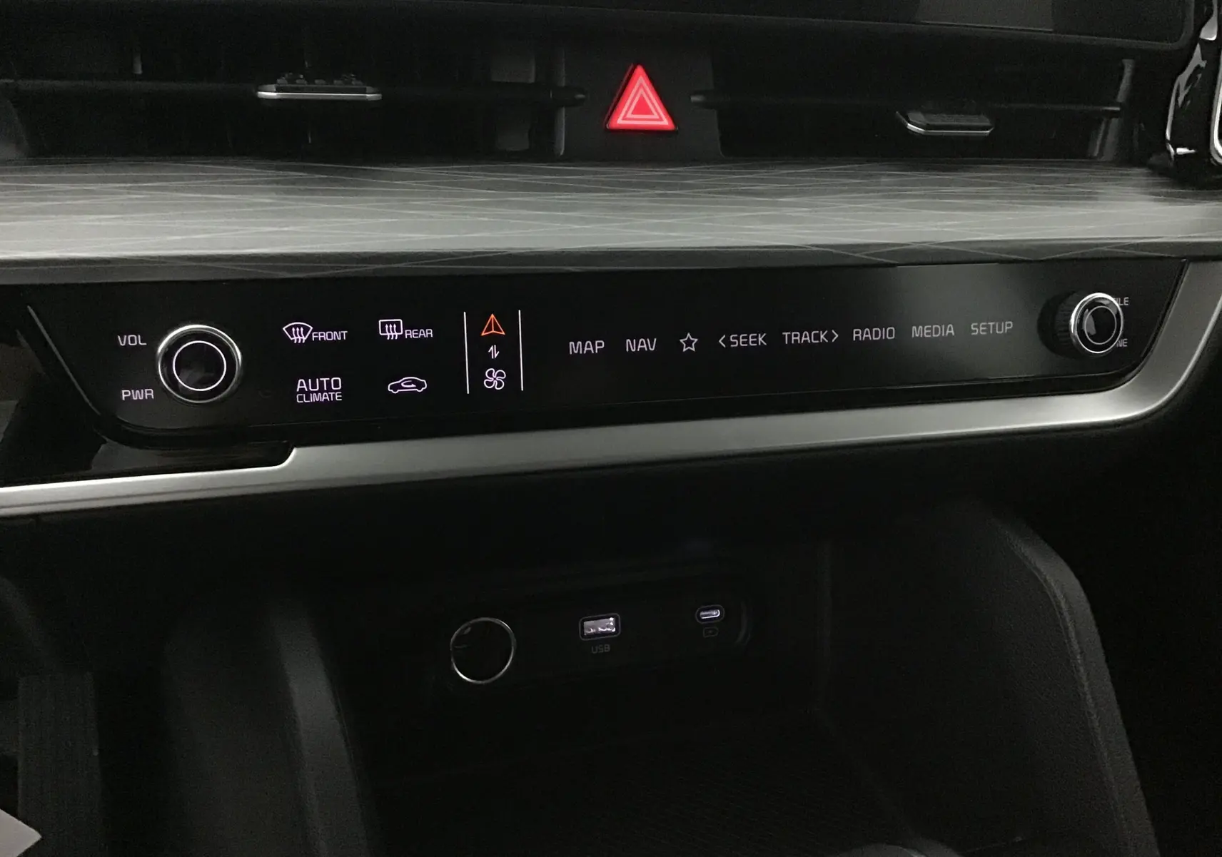 Tableau de bord du Kia Sportage vert Borneo 2025, vue rapprochée sur la console centrale avec commandes tactiles et ports USB.
