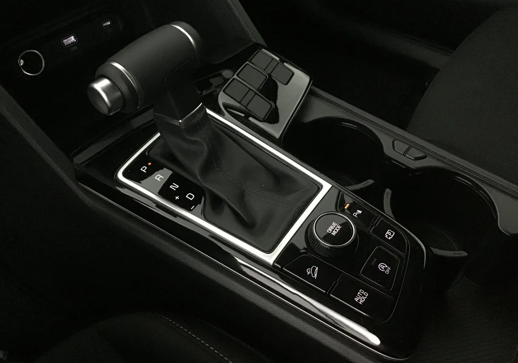 Gros plan sur la console centrale du Kia Sportage 2025, mettant en valeur le levier de vitesses automatique et les commandes de conduite.