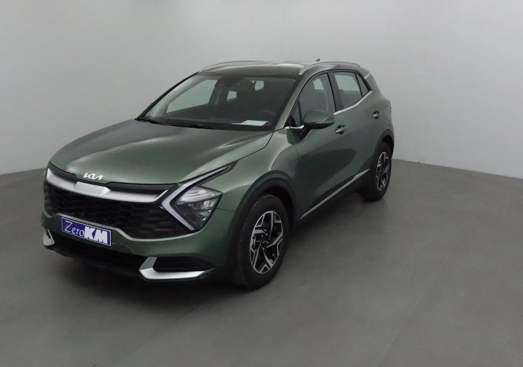 KIA SPORTAGE vert Borneo en 3/4 avant droit, avec calandre noire et jantes alliage noires et argentées.