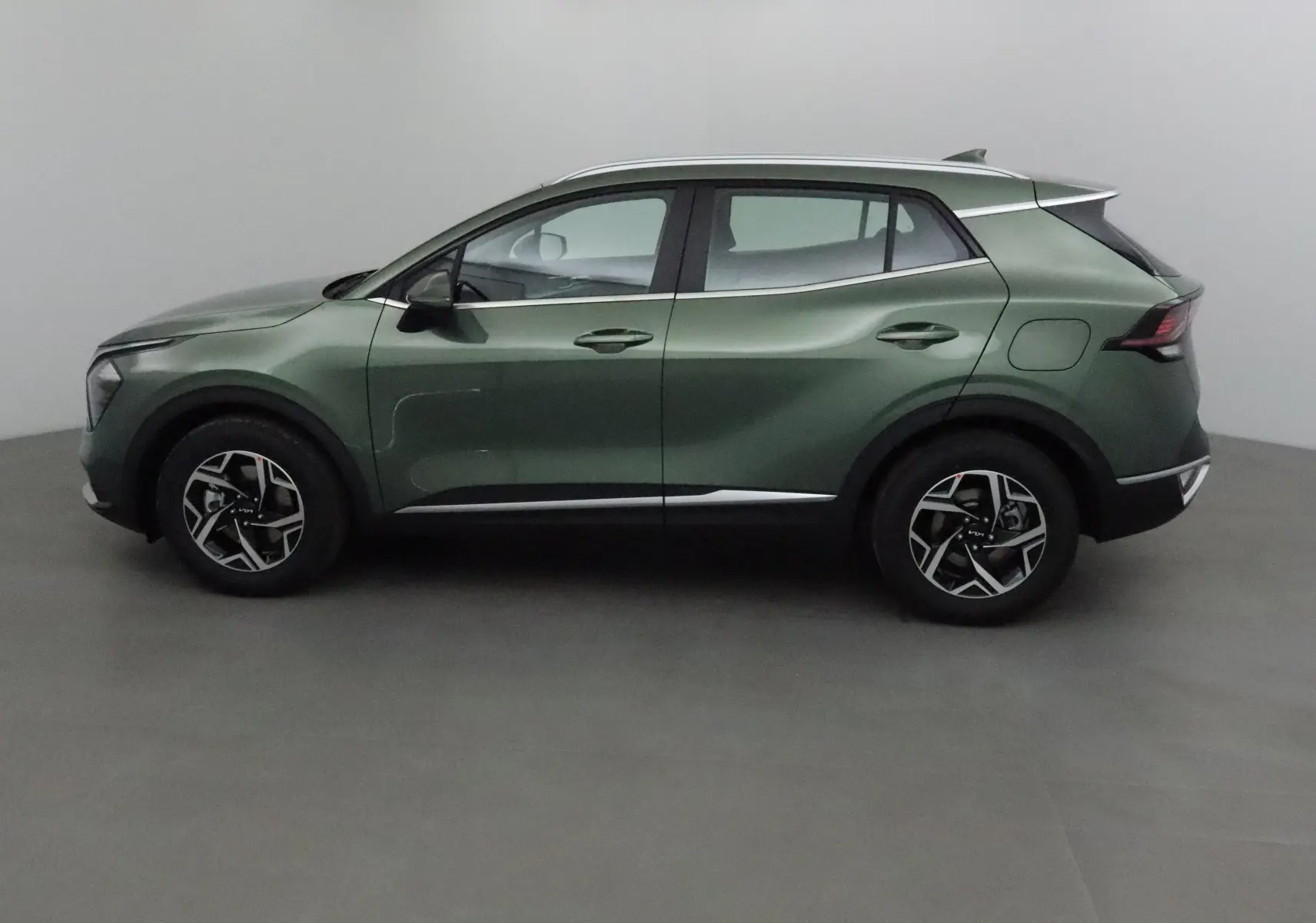 Profil côté gauche du Kia Sportage 2025 vert Borneo avec jantes alliage et lignes sculptées modernes.