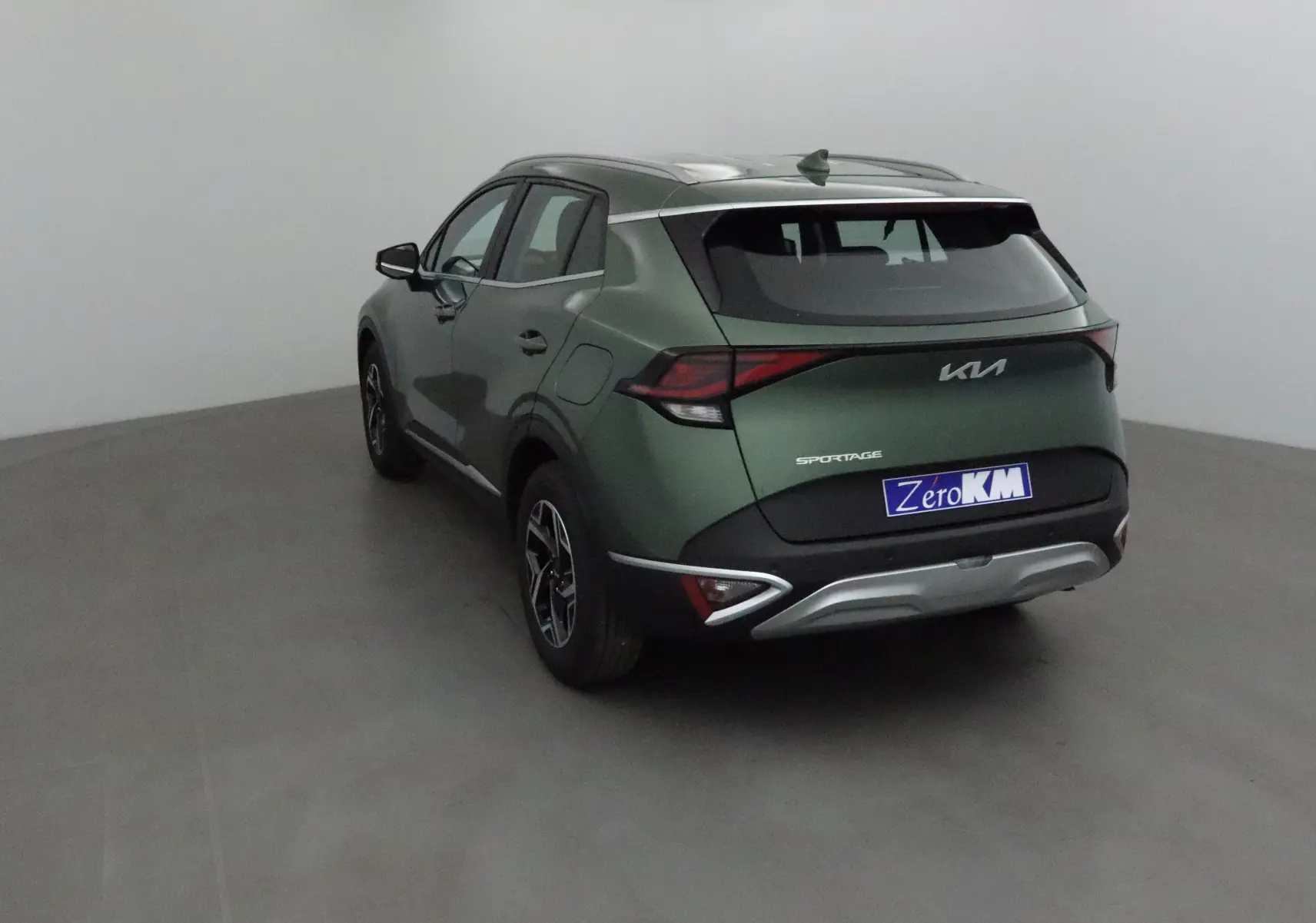 KIA Sportage vert Borneo vu en 3/4 arrière droit, avec feux arrière LED et logo moderne sur hayon.