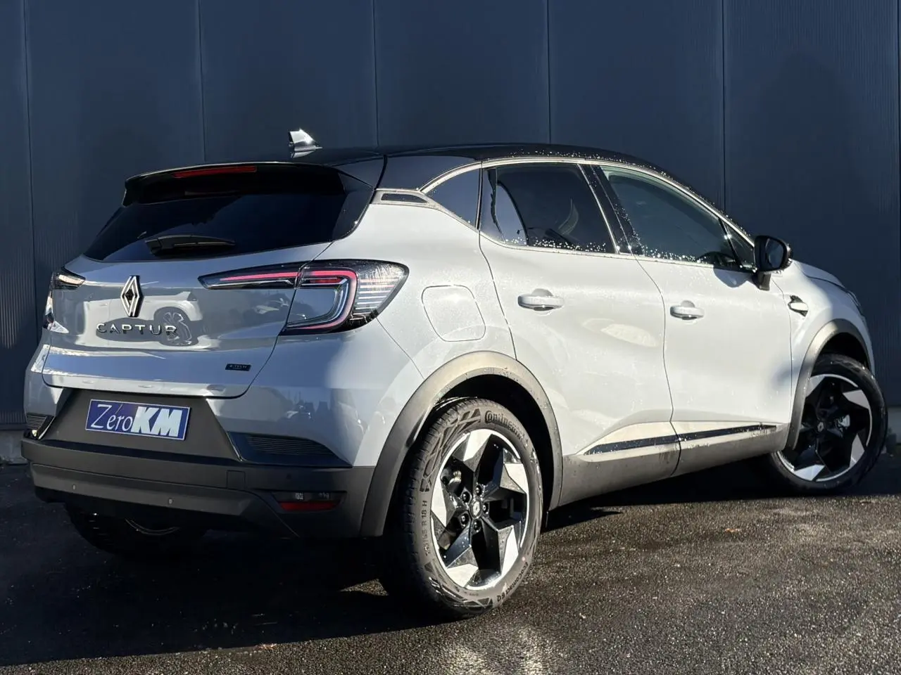 Vue 3/4 arrière droite du Renault Captur gris Rafale avec toit noir et jantes aluminium 18 pouces Black Hole.