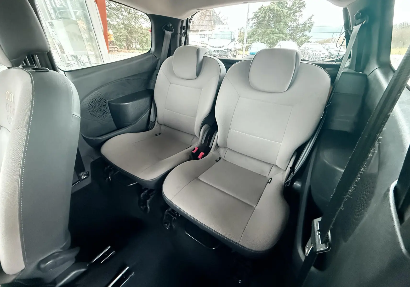 Vue intérieure arrière montrant les deux sièges gris tissu de la Renault Twingo II 2009, côté droit et gauche visibles.