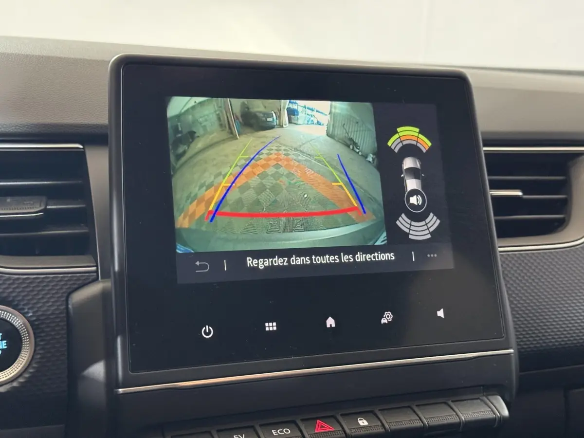 Écran tactile intérieur montrant la caméra de recul et l’aide au stationnement du Renault Arkana gris foncé, vue centrale.