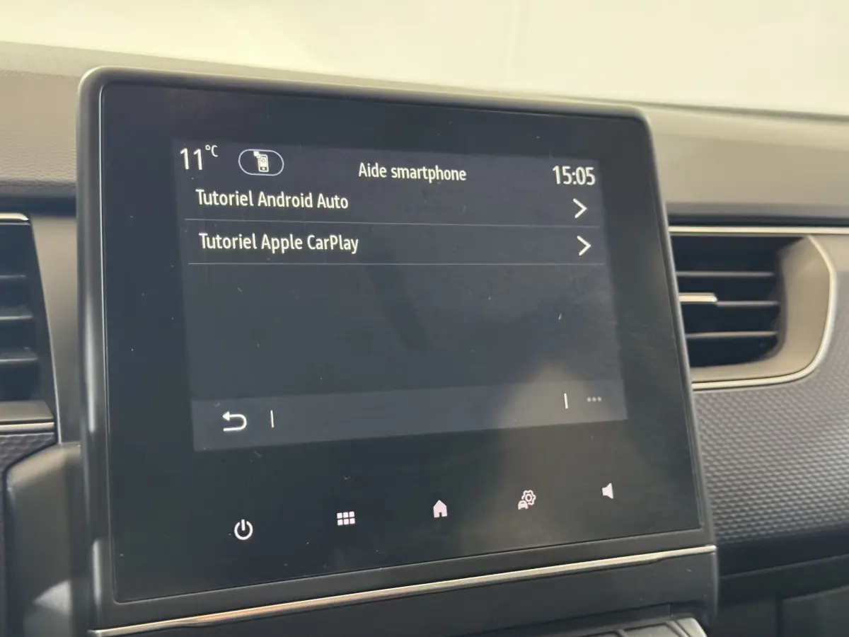 Écran tactile central affichant tutoriels Android Auto et Apple CarPlay dans Renault Arkana Business E-TECH 2022.