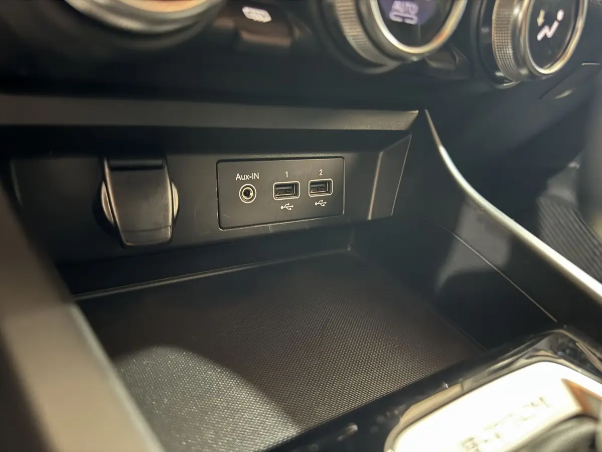Gros plan sur la console centrale du Renault Arkana Business E-TECH 145, montrant les ports USB et prise Aux-In.