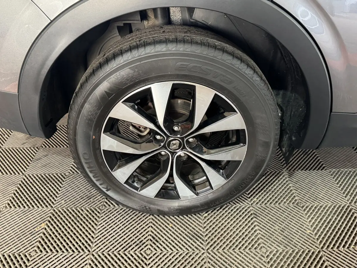 Gros plan sur la roue avant droite avec jante alliage bicolore du Renault Arkana gris foncé Business E-TECH 145.