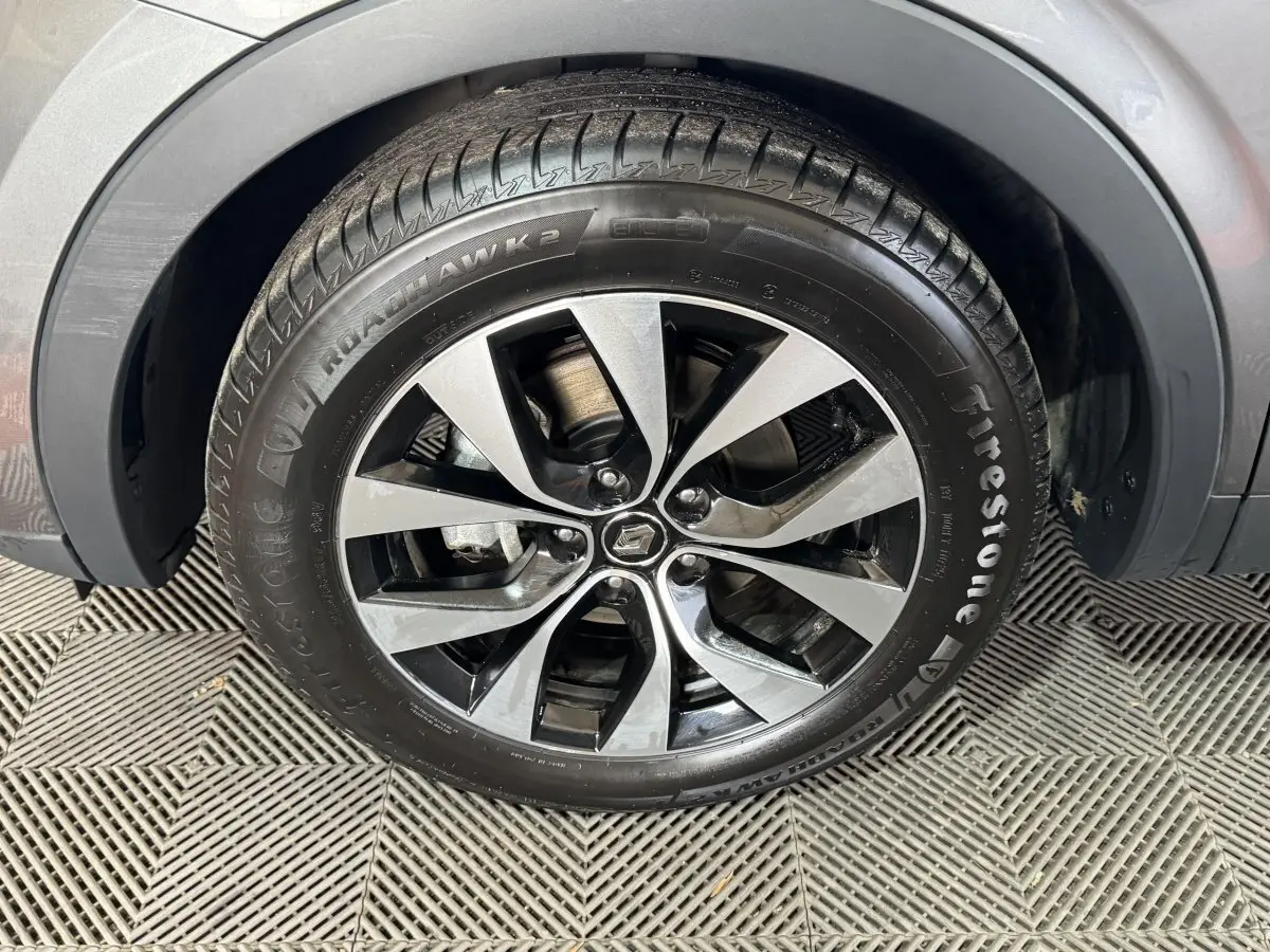 Gros plan sur la roue avant droite avec jante alliage bicolore du Renault Arkana gris foncé Business E-TECH 145.