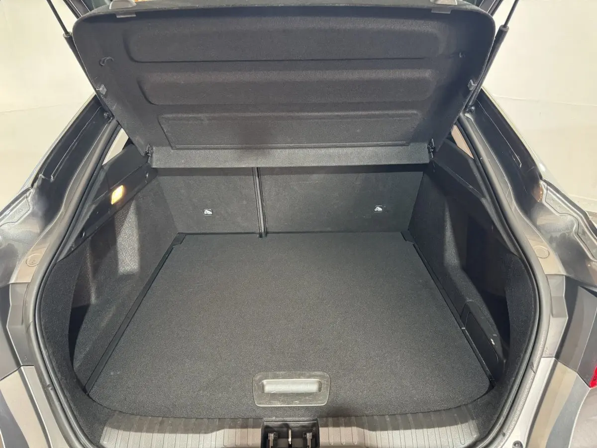 Coffre ouvert vu de l'arrière d'un Renault Arkana Business E-TECH gris foncé, espace de chargement vide et propre.