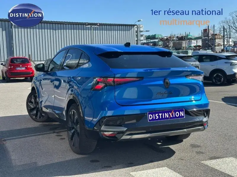 Vue 3/4 arrière droite d'une Renault Rafale 1.2 E-Tech bleu sommet métallisé avec feux arrière LED et jantes noires.