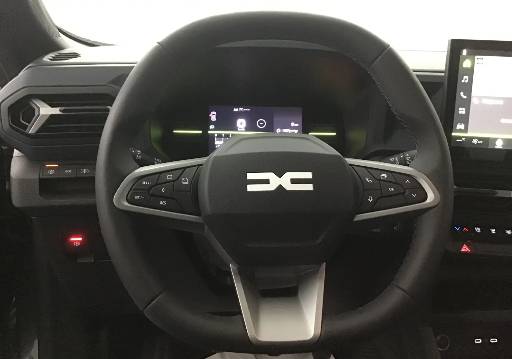 Vue rapprochée du volant noir du Dacia Bigster 2025 avec commandes intégrées et tableau de bord numérique.