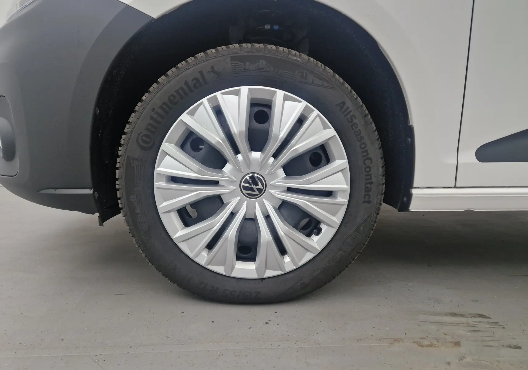 Gros plan sur la roue avant gauche blanche du Volkswagen Caddy Maxi 4Motion avec jante argentée et pneu Continental.